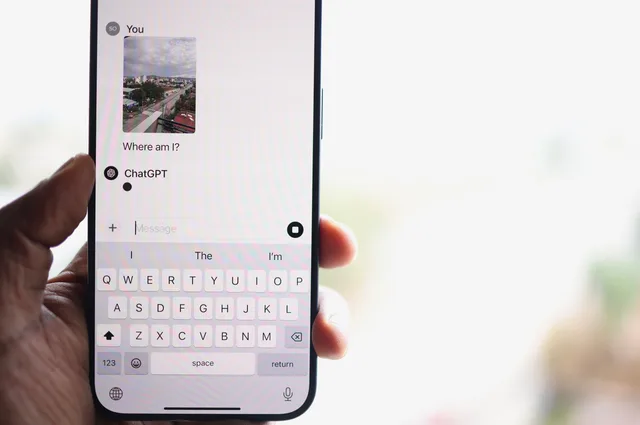 A person holds a smartphone displaying a chat with ChatGPT, inquiring about their location. Effectmeting van reclamecampagnes: opzet, meetmethoden en valkuilen